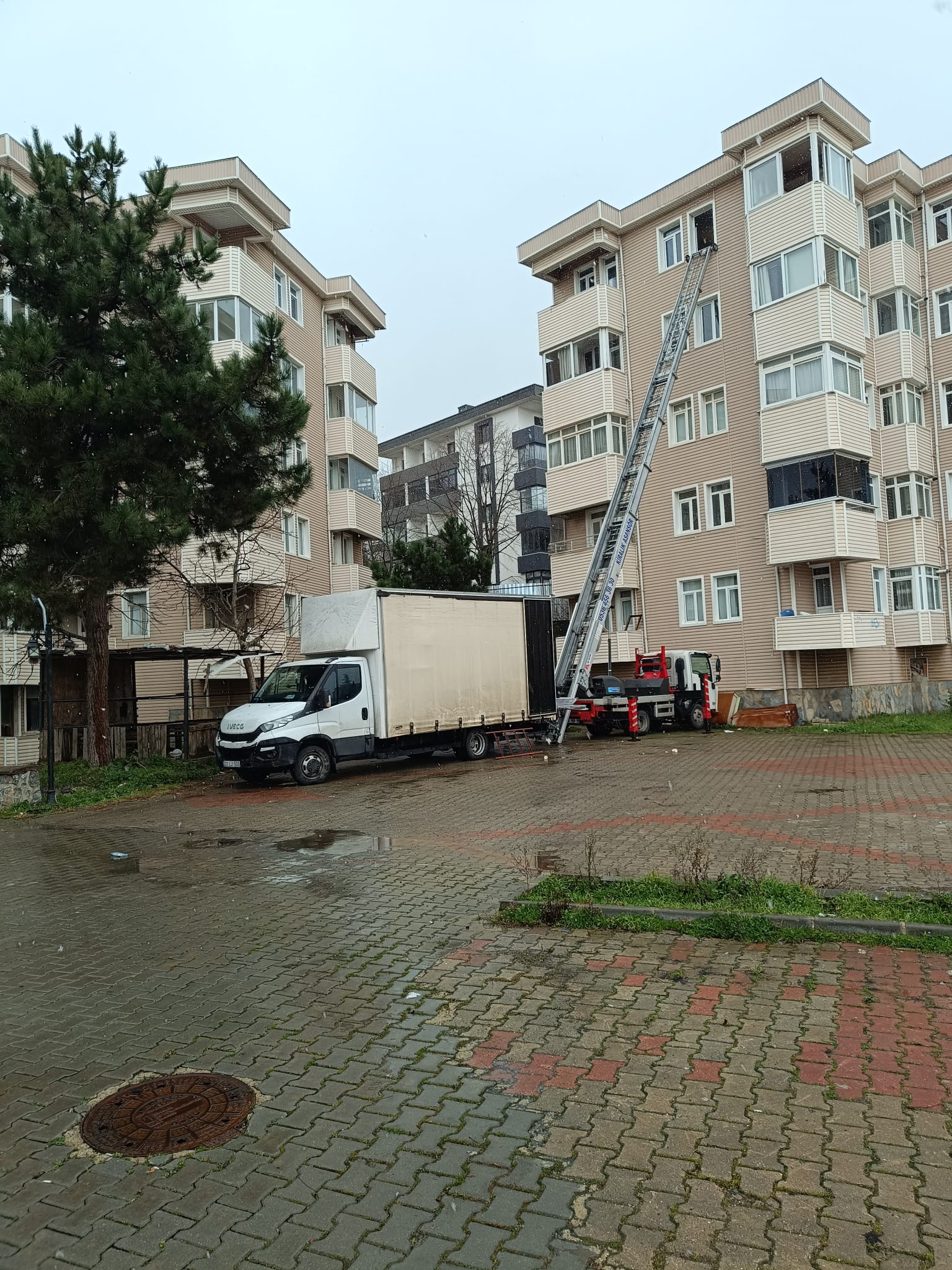 Site içindeki apartmana kurulan dış cephe nakliyat asansörü ve kapalı kasa kamyon